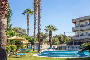 a resort with palm trees and a swimming pool at Dias Studios & Suites in Faliraki