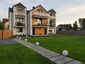 una casa con un patio con bolas blancas en la hierba en CZARNY BARAN, en Dębki