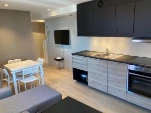 een keuken met een tafel, een wastafel en een aanrecht bij Skansen Apartments in Bergen