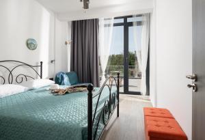 1 dormitorio con 1 cama y balcón en Grand Dodo's Triada Seaview Studios, en Agia Triada
