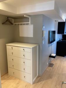 een slaapkamer met een witte dressoir en een tv bij Skansen Apartments in Bergen