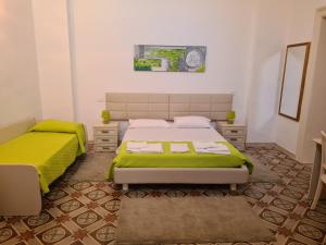 um quarto com 2 camas e lençóis verdes em B&B Il Ventaglio em Parabita
