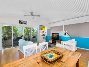 een woonkamer met een tafel en een bank bij Casuarina Beach Shacks 10 with Pool in Kingscliff