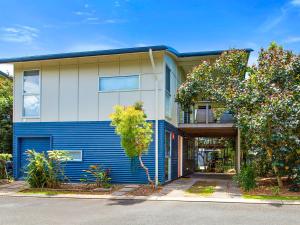 een blauw-wit gebouw met bomen ervoor bij Casuarina Beach Shacks 10 with Pool in Kingscliff