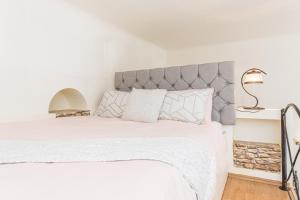 ein Schlafzimmer mit einem weißen Bett mit einem grauen Kopfteil in der Unterkunft Sabin Apartments Private Parking in Braşov