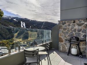 einen Balkon mit einem Tisch, Stühlen und einem Grill in der Unterkunft Lantern 10 Deluxe - Parking in Thredbo