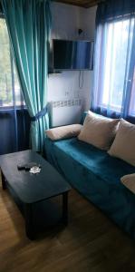 uma sala de estar com um sofá e uma mesa em Къща за гости Вила Отдих Vila Otdih em Apriltsi