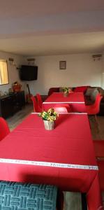 ein Zimmer mit zwei roten Tischen mit Blumen darauf in der Unterkunft Къща за гости Вила Отдих Vila Otdih in Aprilzi