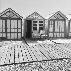 a black and white photo of a building with two benches at Hidden Bay Hotel in Cayeux-sur-Mer