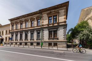a person riding a bike in front of a building at Sabin Apartments Private Parking in Braşov