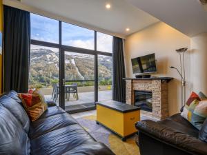 a living room with a couch and a fireplace at Lantern 2 bedroom Terrace with panoramic mountain view in Thredbo