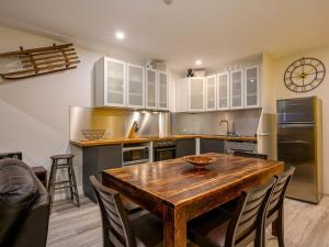 a kitchen with a wooden table and some chairs at Lantern 2 bedroom Terrace with panoramic mountain view in Thredbo