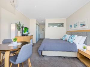 a bedroom with a bed and a desk and a table at Resort and Spa 2306-7 in Kingscliff