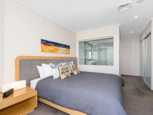 a bedroom with a large bed and a mirror at Resort and Spa 2306-7 in Kingscliff
