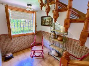 Pokój z czerwonym krzesłem i oknem w obiekcie Precioso Chalet en Almuñecar junto al Mar con Garage privado w Almuñécar