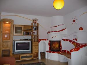 een woonkamer met een tv en een trap bij Biohof Weissensteiner in Ullrichs