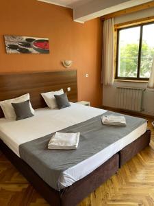 a bedroom with a large bed with two towels on it at Private Rooms Trakiets in Pomorie