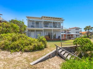 a house on the beach with a fence in front of it at Sandpiper Beachfront House - Hastings Point in Hastings Point