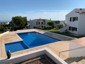 a swimming pool in a yard next to a house at Ca la Marta apartamento con piscina y jardín a 150m de la playa in Arenal d'en Castell