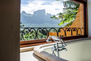 a bath tub in front of a window with a view at Villa Yrondi in Bora Bora