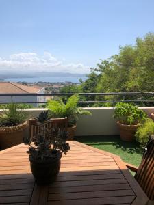 une table en bois sur un balcon avec des plantes en pot dans l'établissement Bel appartement au calme vue imprenable parking privé gratuit, à La Ciotat