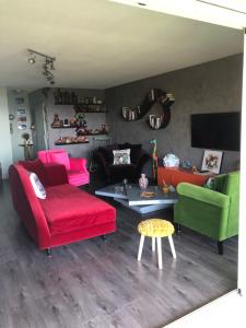 salon z czerwoną kanapą i zielonymi krzesłami w obiekcie Bel appartement au calme vue imprenable parking privé gratuit w mieście La Ciotat