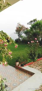 een tuin met roze bloemen en een wandelpad bij Maa Anand Mayee Guest House in Panuānaula