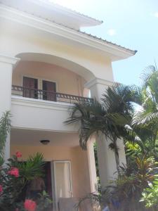 a white house with palm trees in front of it at Residences Beach Apartment in Flic-en-Flac