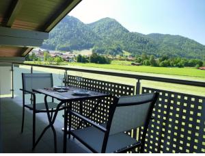 a table and chairs on a balcony with a view at Ferienwohnung Wiesenglück in Ruhpolding