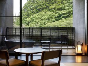 a room with a table and chairs and a large window at Hakone Kowakien Tenyu in Hakone