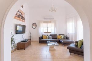 a living room with a couch and a tv at Andrea Villa by Prestige Bookings in Peyia