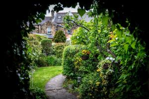 um jardim com flores e uma casa ao fundo em Homelands Guest House em Barnard Castle