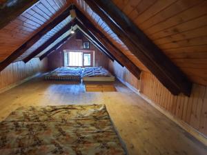 an attic room with two beds and a window at La Baita di Heidi in Craveggia