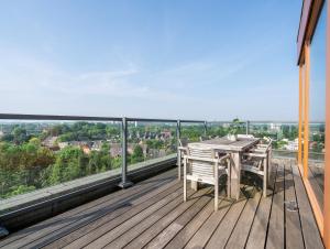 a wooden deck with a table and chairs on a balcony at Alpine Hotel by SnowWorld in Landgraaf