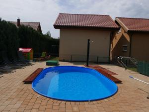 a large blue swimming pool in a backyard at Ferienhäuser mit Pool in Rewal