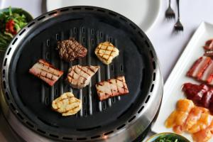 a black grill with some food on it at Alpine Hotel by SnowWorld in Landgraaf