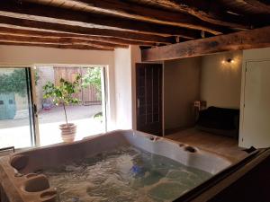 a large bath tub in the middle of a room at Domaine de la Fée-Licité in Jullié