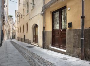 an empty street with a brown door on a building at Host 98 in Cagliari