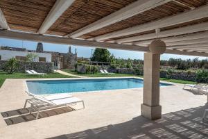 a large pool with a bench in front of it at Masseria Berzario in Melendugno