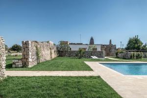 a large stone building with a pool in front of it at Masseria Berzario in Melendugno