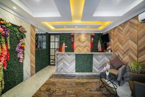 una hall con una parete verde e fiori di Tree Homestay Mitra RedDoorz a Kasri