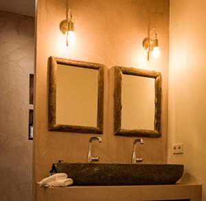 baño con 2 espejos y lavamanos de piedra en EgliZen, en Hoofdplaat