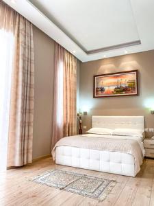 ein Schlafzimmer mit einem weißen Bett und einem Fenster in der Unterkunft Hotel Vila Verde City Center in Tirana