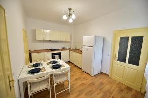 eine Küche mit einem Tisch und einem weißen Kühlschrank in der Unterkunft FLH - House Angelique in Sibiu