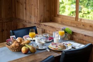 a table with breakfast foods and orange juice on it at Alpine Hotel by SnowWorld in Landgraaf