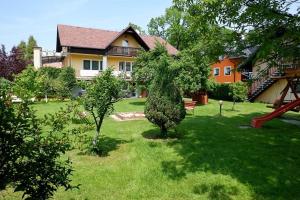 a house with a tree in the middle of a yard at Pokoje Gościnne "Adam" in Ustroń