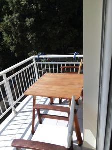 una mesa de madera en una terraza con barandilla en Alexandra rooms, en Skala Potamias