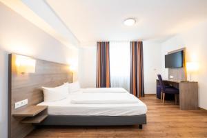 a hotel room with a bed and a desk at Bamberg Inn in Hallstadt