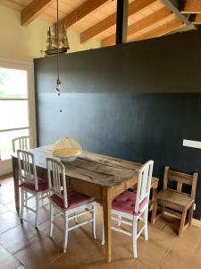 a wooden table and chairs in a room with a wall at 4 bedrooms villa with private pool enclosed garden and wifi at Camallera in Camallera