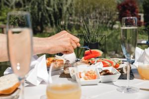 a person eating food on a table with wine glasses at Kohlerhof - 4 Star Wellness & Active Hotel in Fügen